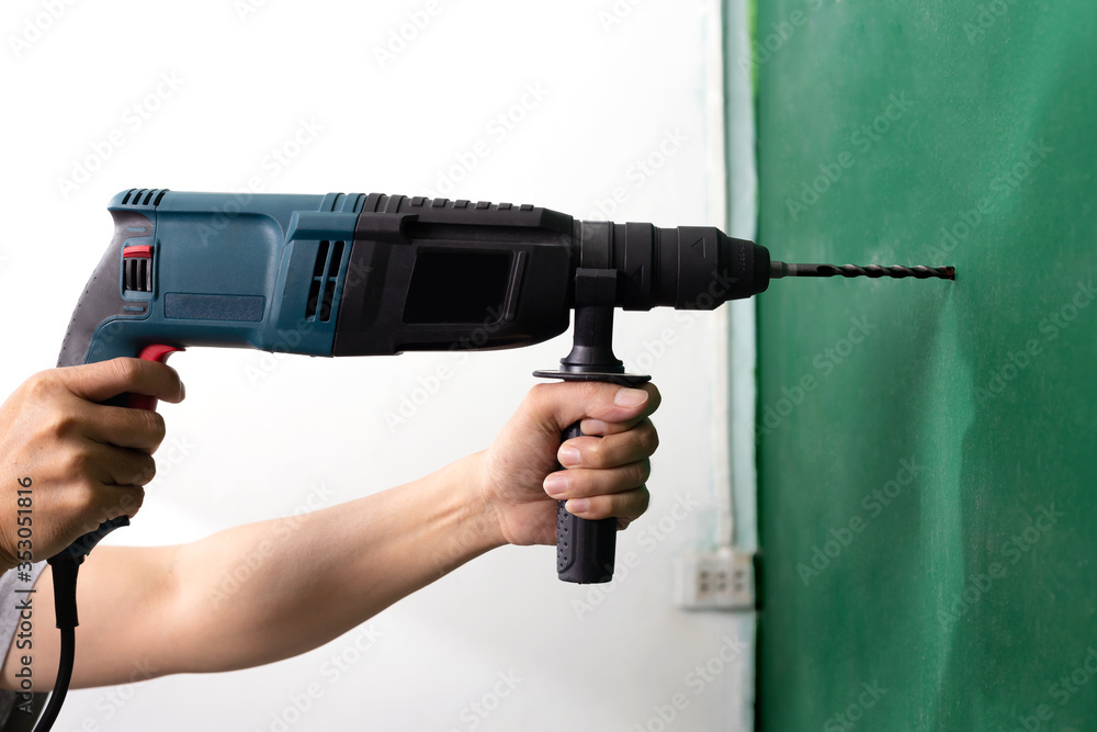 Man hand holding Rotary hammer drill to penetrate the wall isolated on white background Man hand holding Rotary hammer drill to penetrate the wall isolated on white background