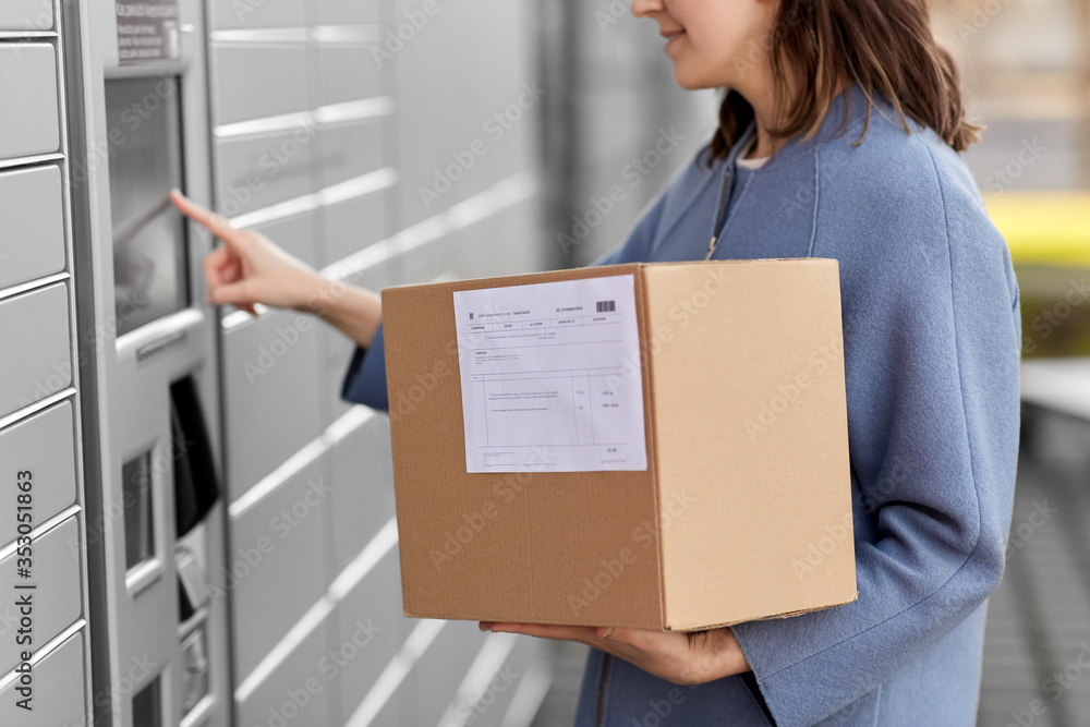 mail delivery and post service concept - close up of happy smiling woman with box at outdoor automated parcel machine choosing operation on touch screen mail delivery and post service concept - close up of happy smiling woman with box at outdoor automated parcel machine choosing operation on touch screen