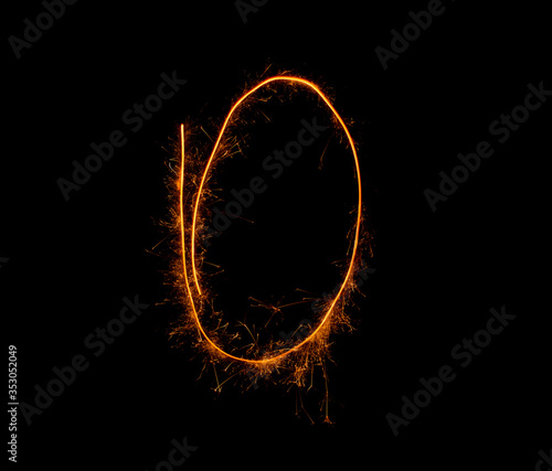 number zero written with a sparkler on a black background