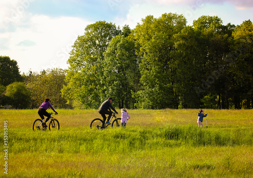 People riding bicycles on a road in summertime weekends and beautiful landscape © vita