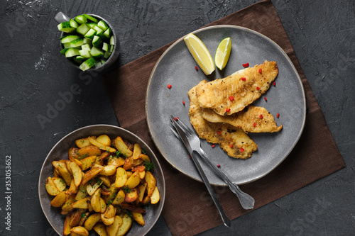 Fried breaded hake fillet with spice and roasted potato wedges