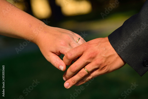 Newlyweds holding hands with rings at wedding