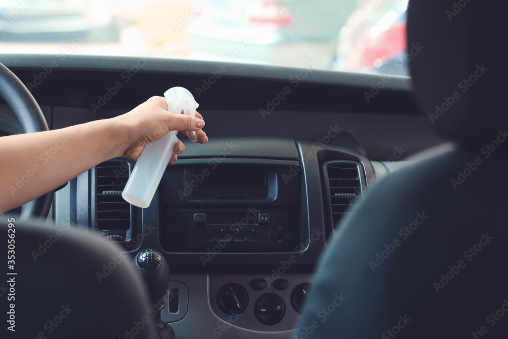 Woman disinfecting salon of car