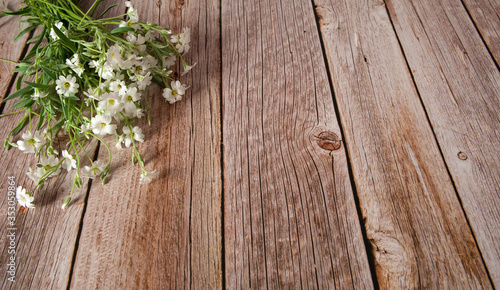Flower composition. A bouquet of wild white wildflowers on a wooden background. Selective focus. Free space.