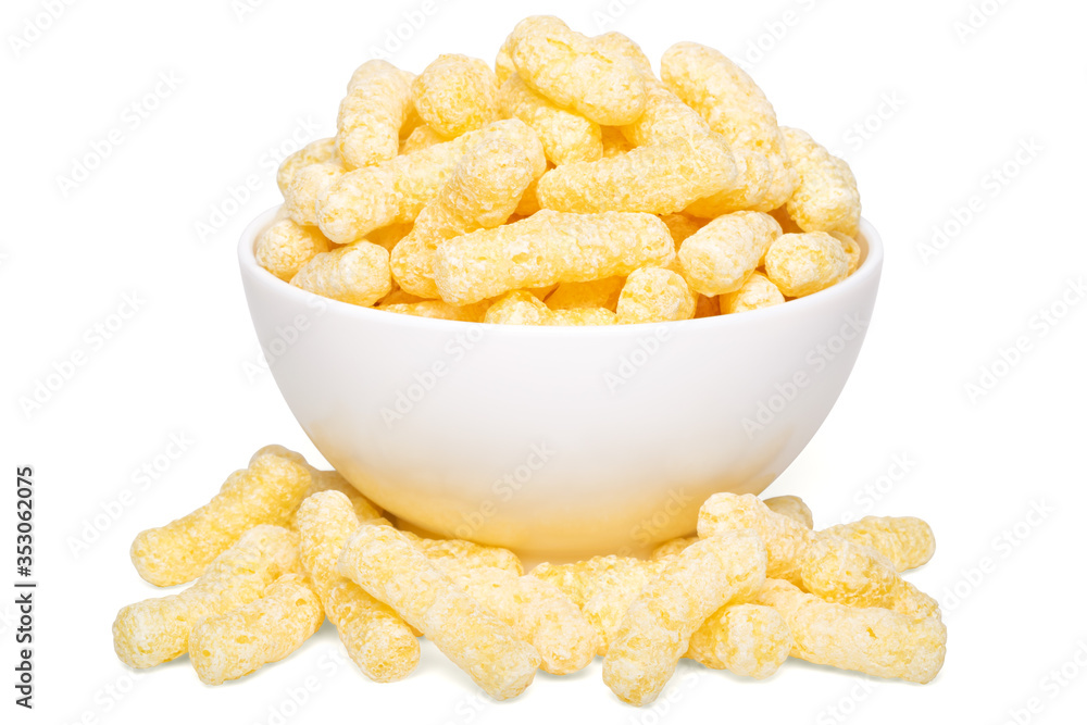 Obraz premium A heap of corn snacks. Sweet sticks of puffcorn. Dry breakfast in white bowl