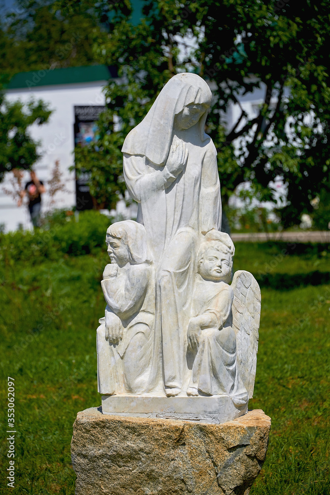 Russia, Kazan June 2019. Statue of a woman with angels made of white stone. Christian sculpture. Religious stone statue.