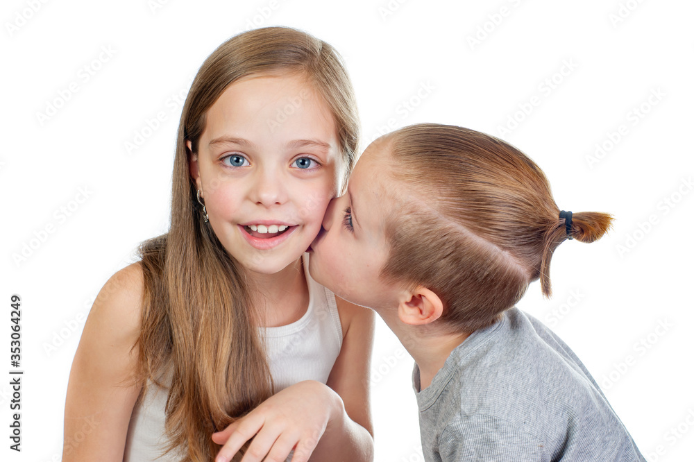 Young smiling caucasian girl and boy kisses her on the cheek isolated on white background Young smiling caucasian girl and boy kisses her on the cheek isolated on white background