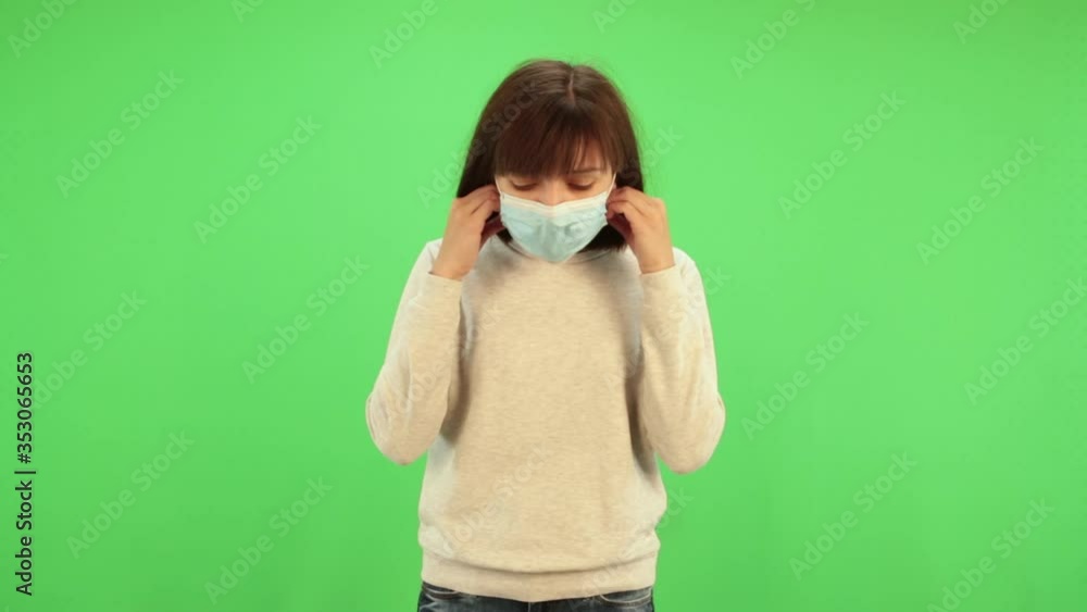 Woman puts on medical mask on chromakey. Virus protection gel, disinfectant. Prevent spread of coronavirus covid-19. Woman puts on medical mask on chromakey. Virus protection gel, disinfectant. Prevent spread of coronavirus covid-19.
