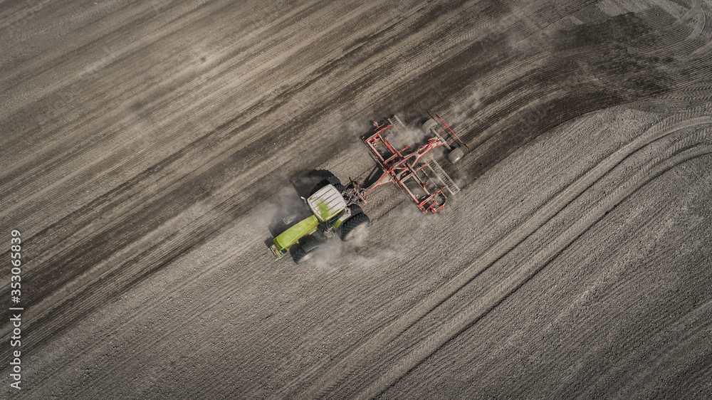 Farmers cultivating. Tractor makes vertical tillage. Aerial view