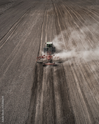 Tableau sur toile Farmers cultivating. Tractor makes vertical tillage. Aerial view