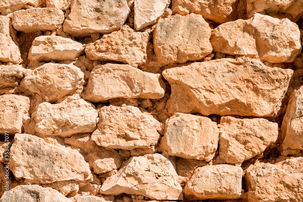 Old rustic man-made Spanish sand stone wall using only natural materials. The wall is in a bad condition and has been aged and dried out by the sun over the years. Old rustic man-made Spanish sand stone wall using only natural materials. The wall is in a bad condition and has been aged and dried out by the sun over the years.