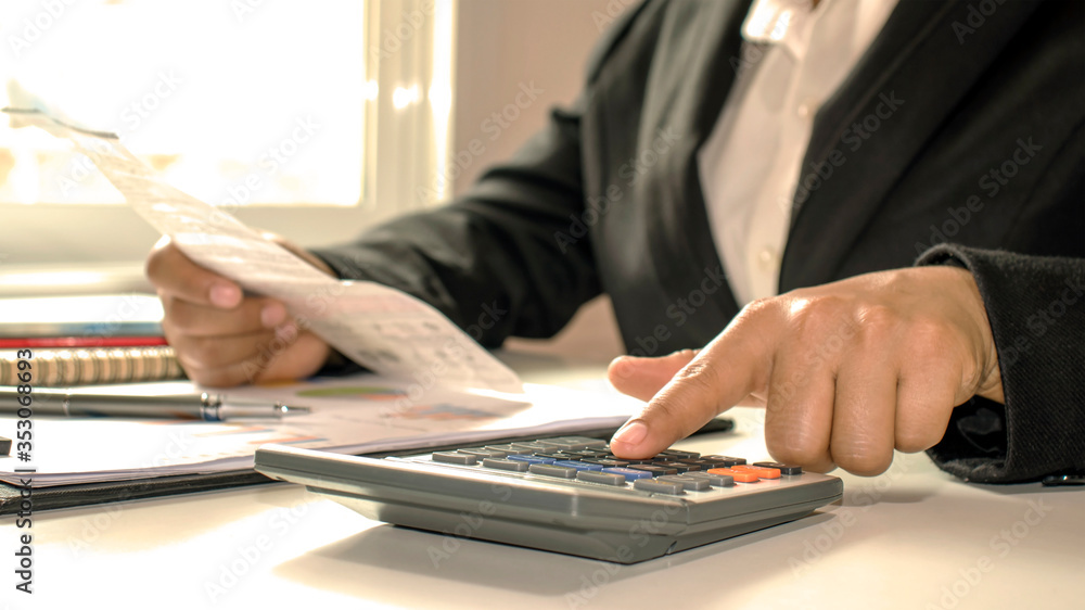 Close-up of businessmen or accountants holding a pen and pressing on the calculator to calculate business information, accounting documents, business ideas. Close-up of businessmen or accountants holding a pen and pressing on the calculator to calculate business information, accounting documents, business ideas.
