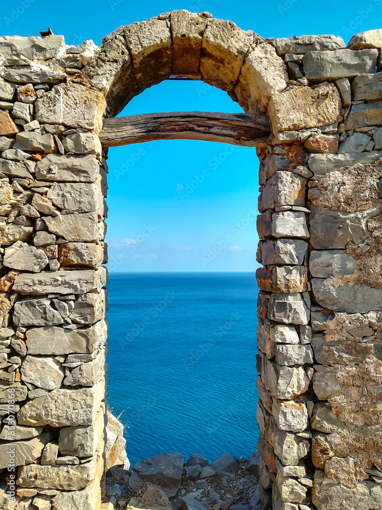 old doorway on spina longa island with view on the sea