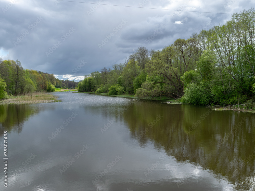 spring landscape with a river, the first bright spring greenery on the river bank spring landscape with a river, the first bright spring greenery on the river bank