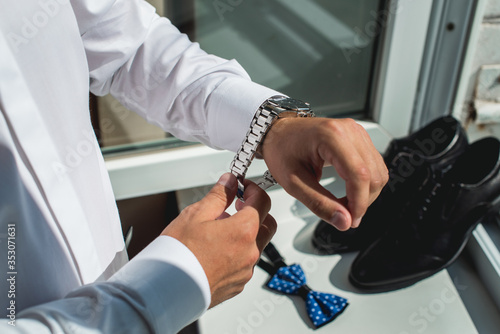 Foto businessman checking time on his wrist watch, man putting clock on hand, groom g