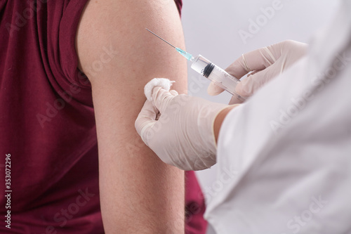 The doctor s hands are close-up. the doctor gives an injection to the person. Seasonal vaccination. Inoculation. Coronavirus.