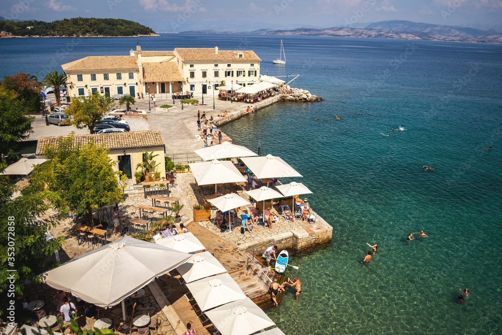 CORFU, GREECE - 10.09.2019 - Faliraki beach Alecos Baths public bathing spot with rock and pier ans restaurant in Corfu Town, Ionian Sea