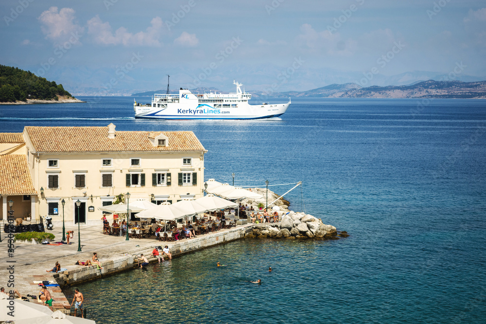 CORFU, GREECE - 10.09.2019 - Faliraki beach Alecos Baths public bathing spot with rock and pier ans restaurant in Corfu Town, Ionian Sea