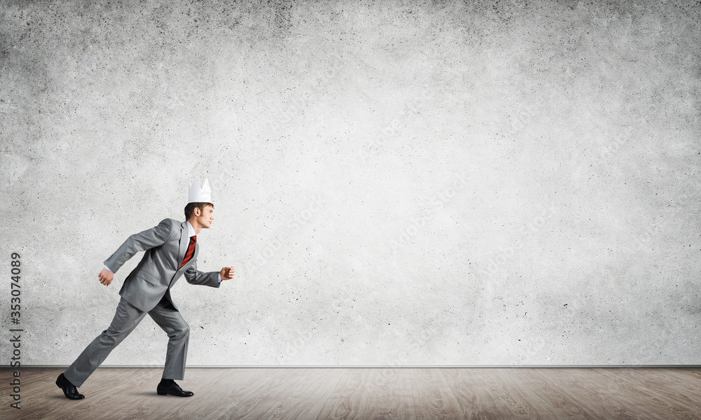 King businessman in elegant suit running in empty room with wooden floor King businessman in elegant suit running in empty room with wooden floor