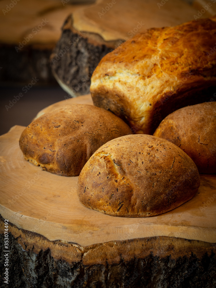 A close up shot of a home made bread on a rustic wood board.