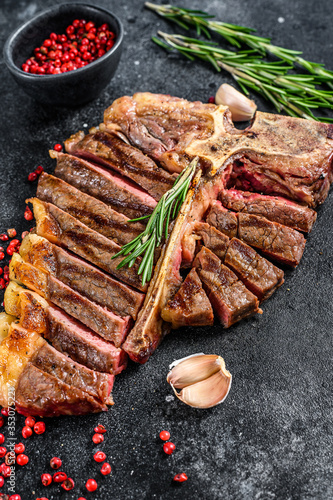 Grilled T-bone steak. Cooked tbone beef. Black background. Top view