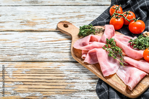 Sliced ham. Fresh prosciutto. Pork ham sliced. White wooden background. Top view. Copy space