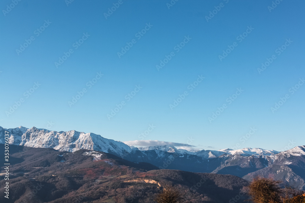 Landscape of high snowy mountains in a winter time during a sunny day with blue sky