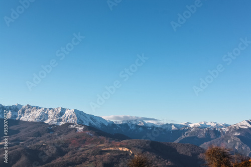 Landscape of high snowy mountains in a winter time during a sunny day with blue sky