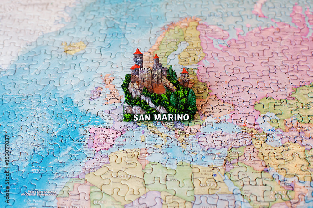 Tourist attractions and souvenir of San Marino on background map of world of puzzles for travelers. Copy space