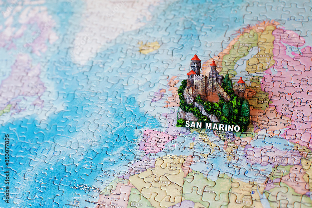 Naklejka premium Tourist attractions and souvenir of San Marino on background map of world of puzzles for travelers. Copy space