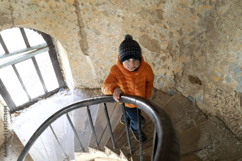 Child on spiral staircase in abandoned building