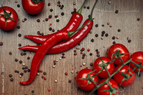 Red ripe fruits of chili pepper and cherry tomato with peppercorns