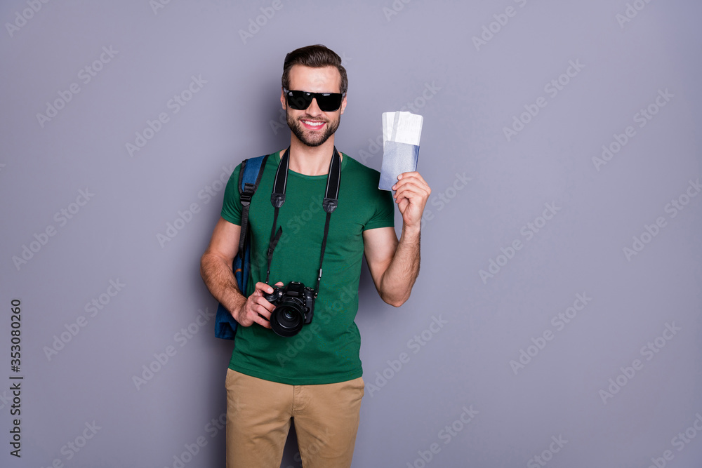 Portrait of positive cheerful traveler man hold tickets visa backpack have professional hobby camera ready enjoy voyage tour wear green stylish trousers isolated gray color background Portrait of positive cheerful traveler man hold tickets visa backpack have professional hobby camera ready enjoy voyage tour wear green stylish trousers isolated gray color background