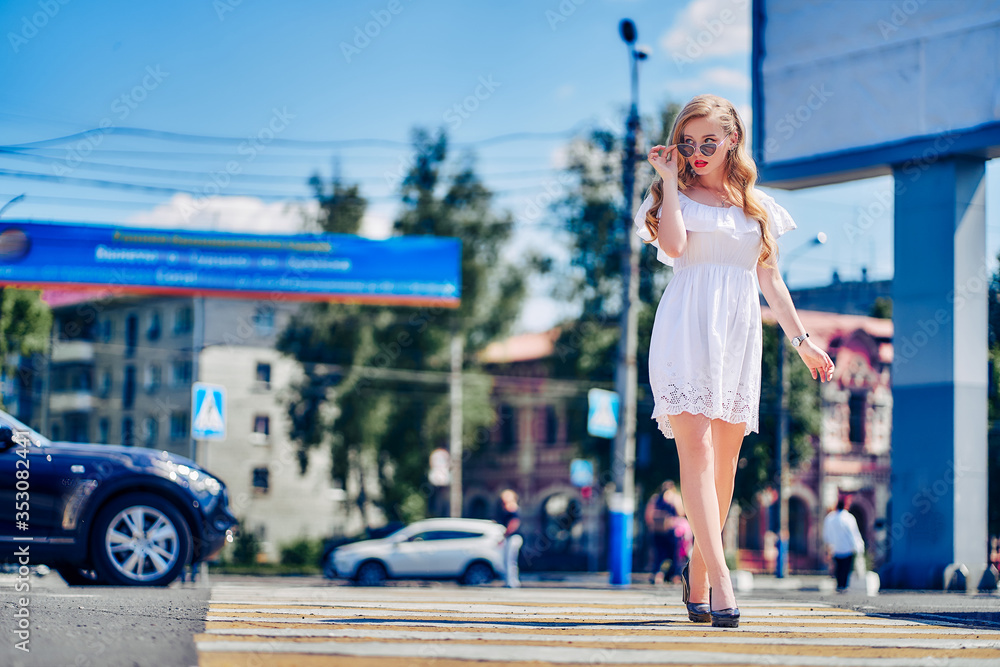 young woman in white sundress and sunglasses on a supermarket parking
