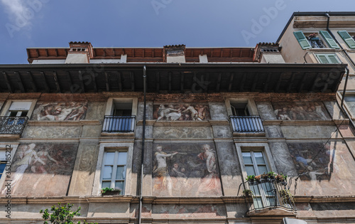Fragment of the facade of an old building decorated with frescoes. Brescia, Italy. Soft focus, blurry background.