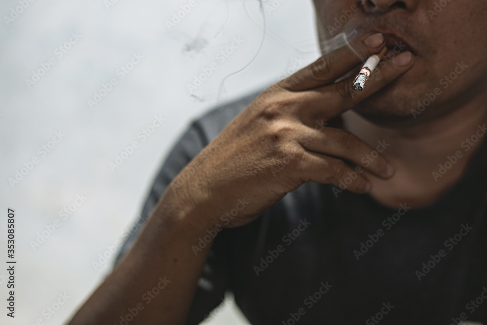 Young man smoking cigarette and bad habits concept