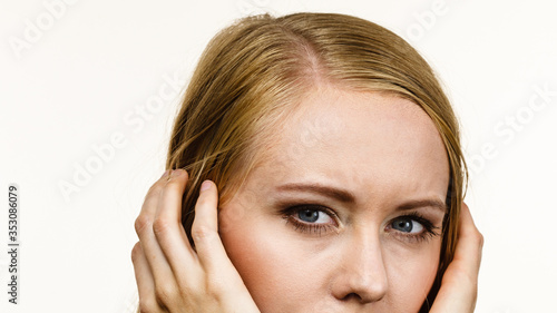 Young woman covers ears with hands. Attitude reaction
