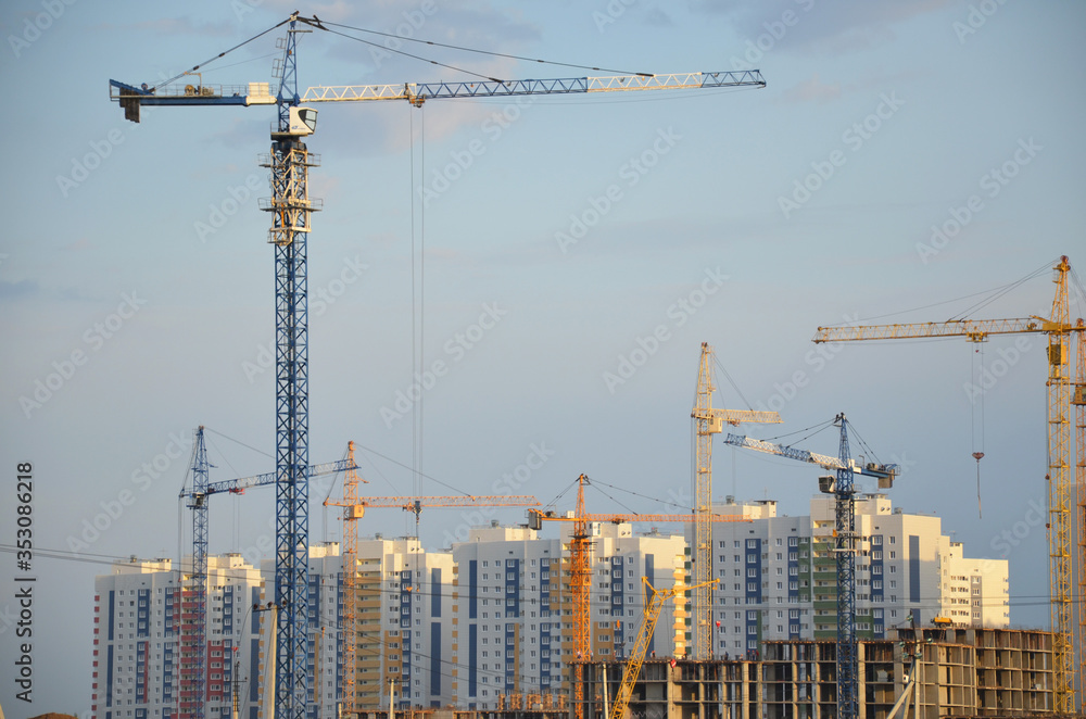 Inside place for many tall buildings under construction and cranes under a blue sky working on place with tall homes Inside place for many tall buildings under construction and cranes under a blue sky working on place with tall homes