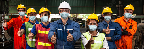 Group of Worker wearing face shield or disposable face mask work in factory to help prevent and fight Coronavirus(Covid-19) or Air dust pollution together wide banner.