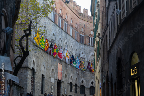 Fototapeta Naklejka Na Ścianę i Meble -  View of a street in town center of Siena with the flags of contrade