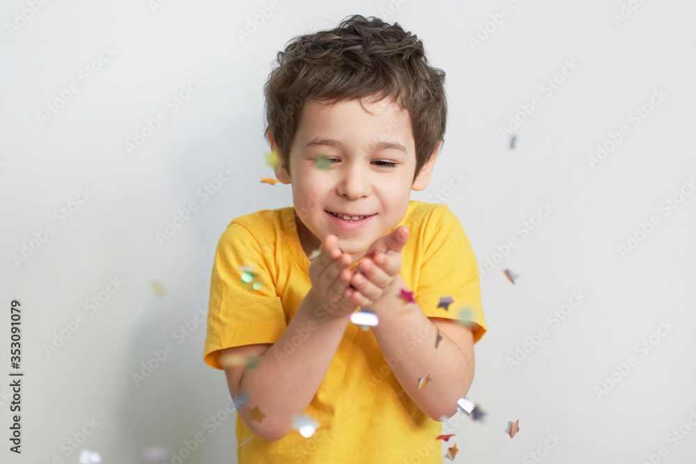 happy birthday child. Photo of charming cute fascinating nice little boy blowing confetti at you to show her festive mood with emotional face expression.
