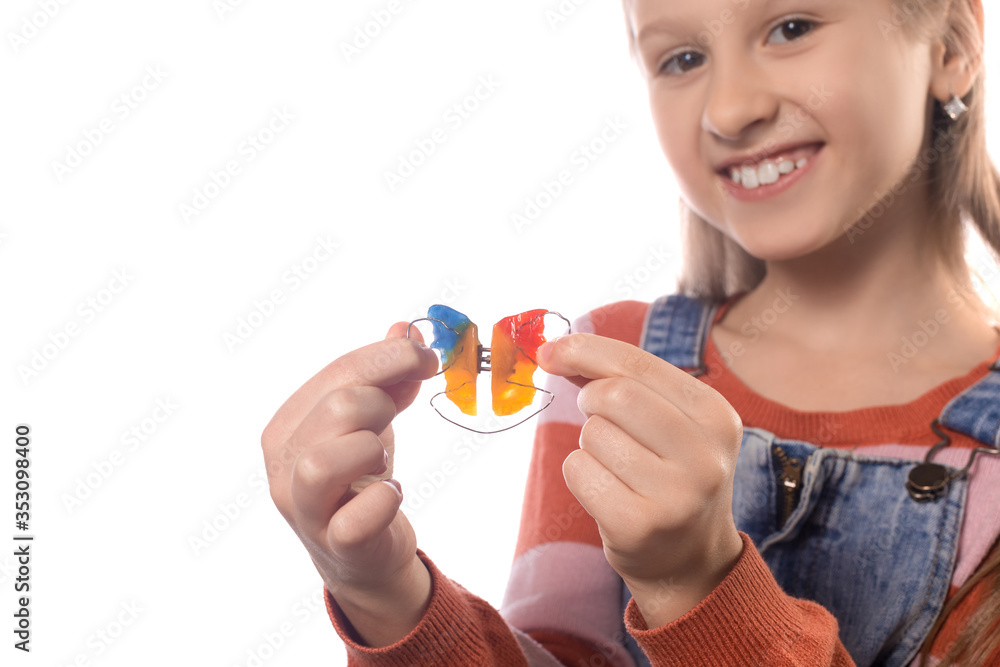 Little girl with orthodontics appliance isolated on white background. Little girl with orthodontics appliance isolated on white background.