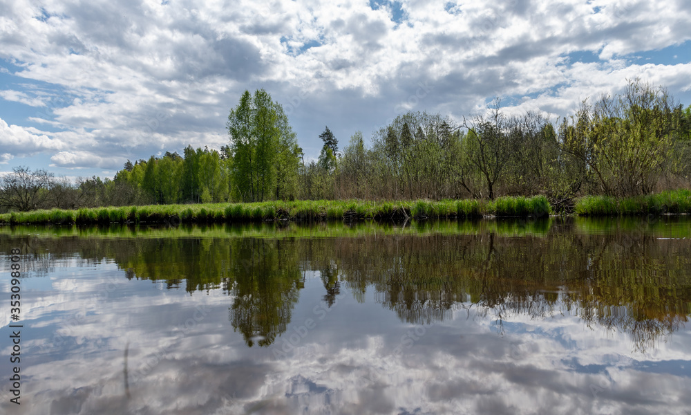 landscape with a beautiful river in spring, cloud reflections in the water