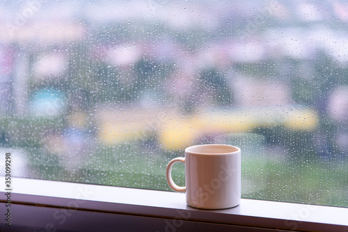 break time with a cup of coffee during raining at window with city view