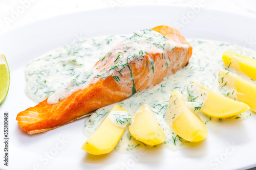 baked salmon with creamy dill sauce and potatoes photo