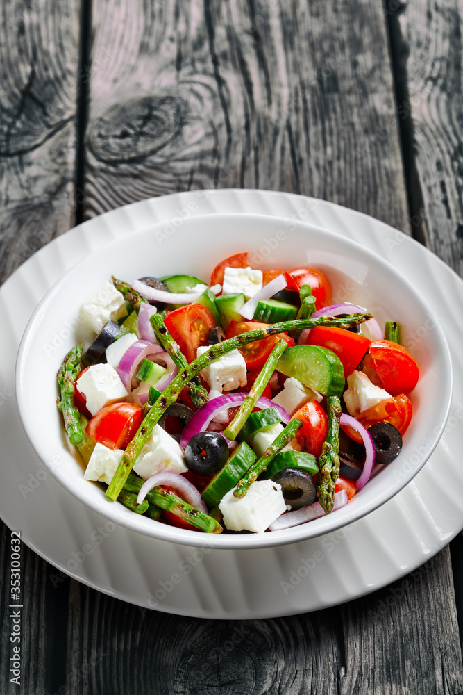 Feta salad with green grilled asparagus on a bowl