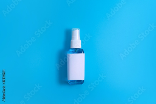 Top down view skincare blue alcohol liquid for medical purpose and Anti coronavirus COVID-19 (Ethanol or ethyl alcohol) in a plastic spray bottle with blank label on plain blue isolated background.