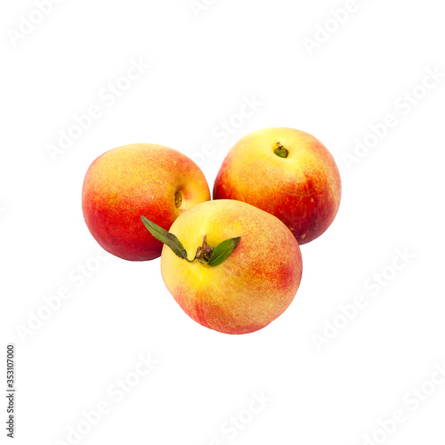 three ripe yellow and red nectarines with green leaves isolated on a white background