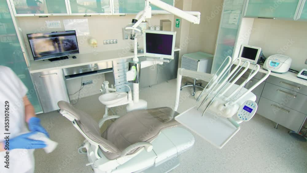 Female dentist cleaning equipment in dentists office Female dentist cleaning equipment in dentists office