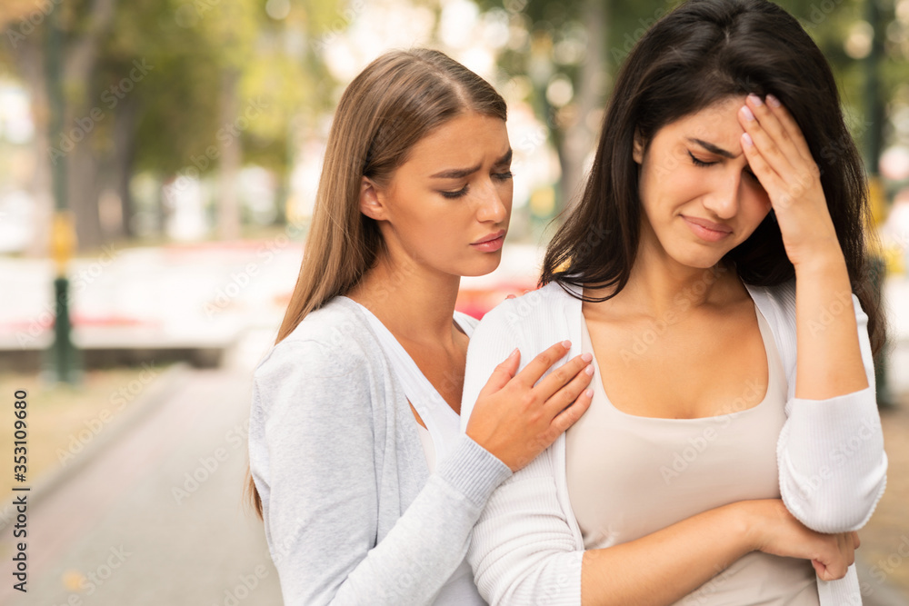 Compassionate Friend Supporting Crying Girl Standing In Park Compassionate Friend Supporting Crying Girl Standing In Park